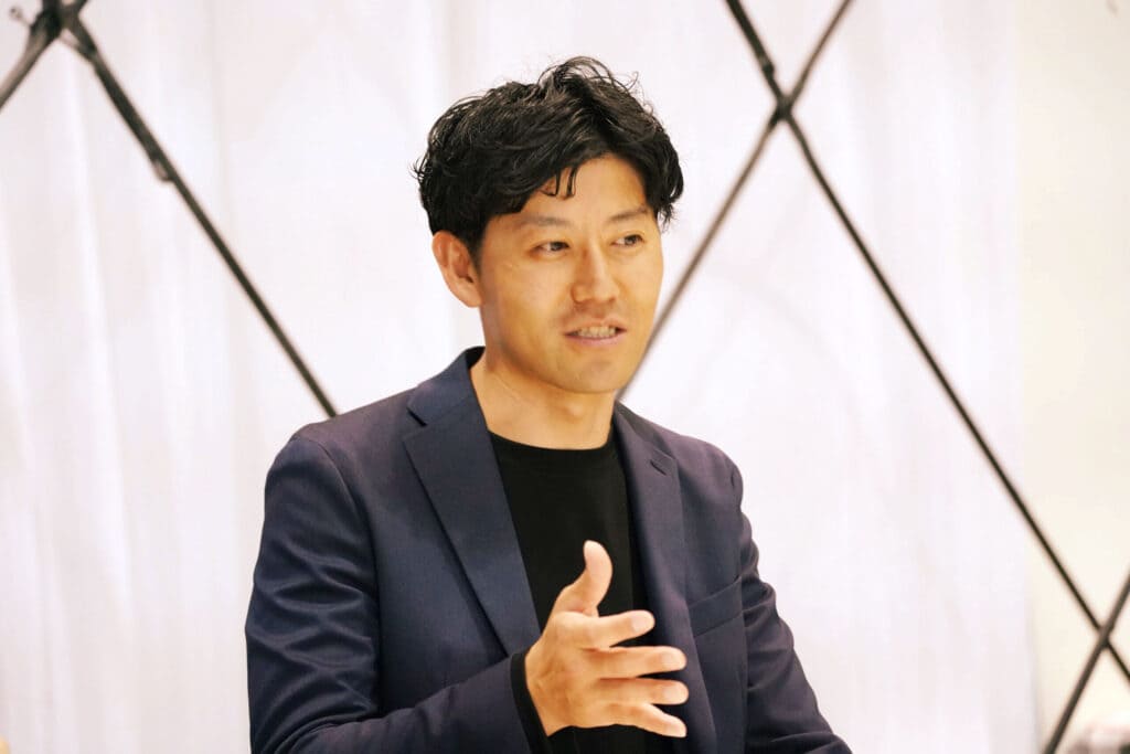 身振りを交えて、TIB Studentsの期待と魅力を語る池田巧氏。